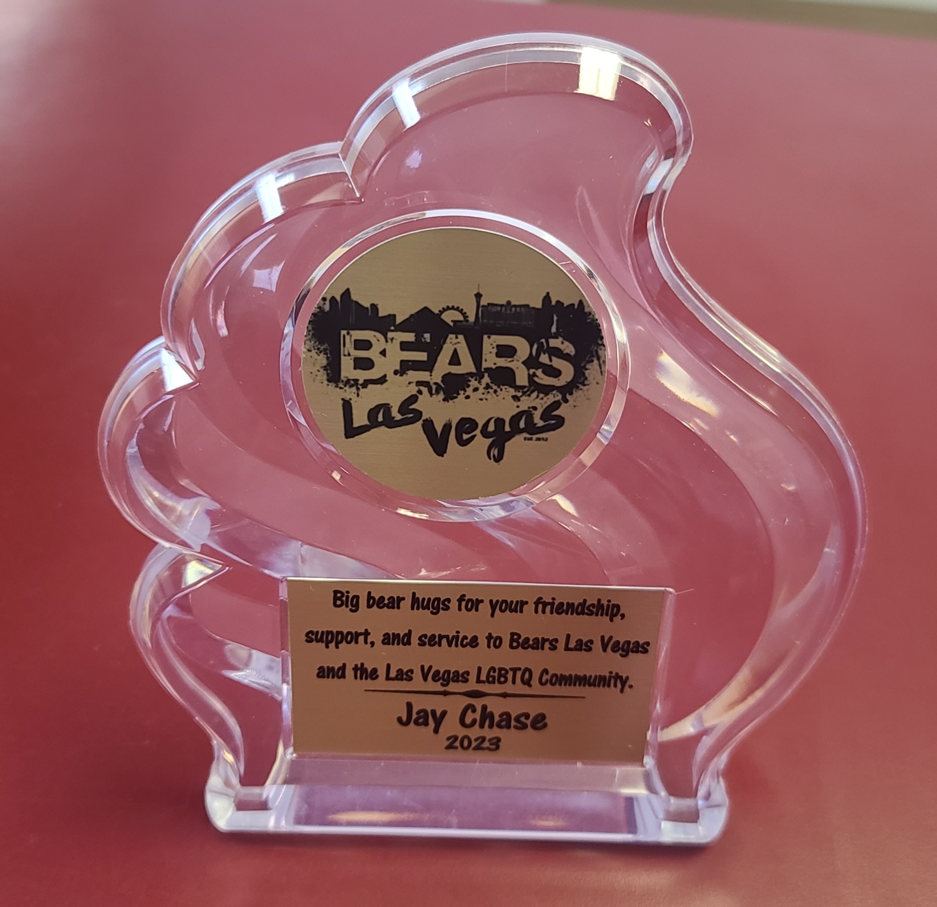 Clear acrylic bear-shaped award with gold logo medallion and engraved recognition plate for community service