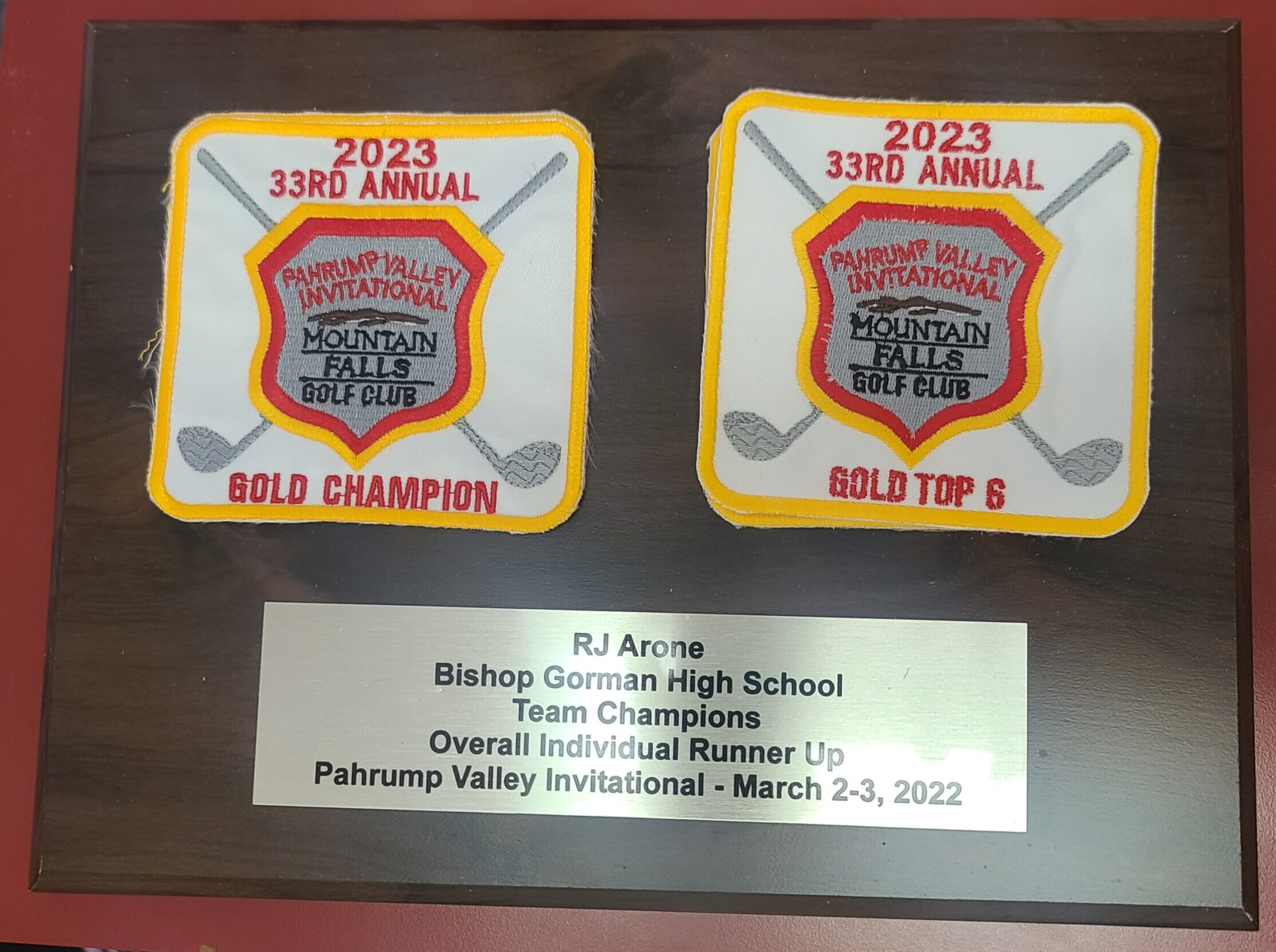 Walnut plaque with embroidered golf tournament patches and engraved silver plate for championship recognition