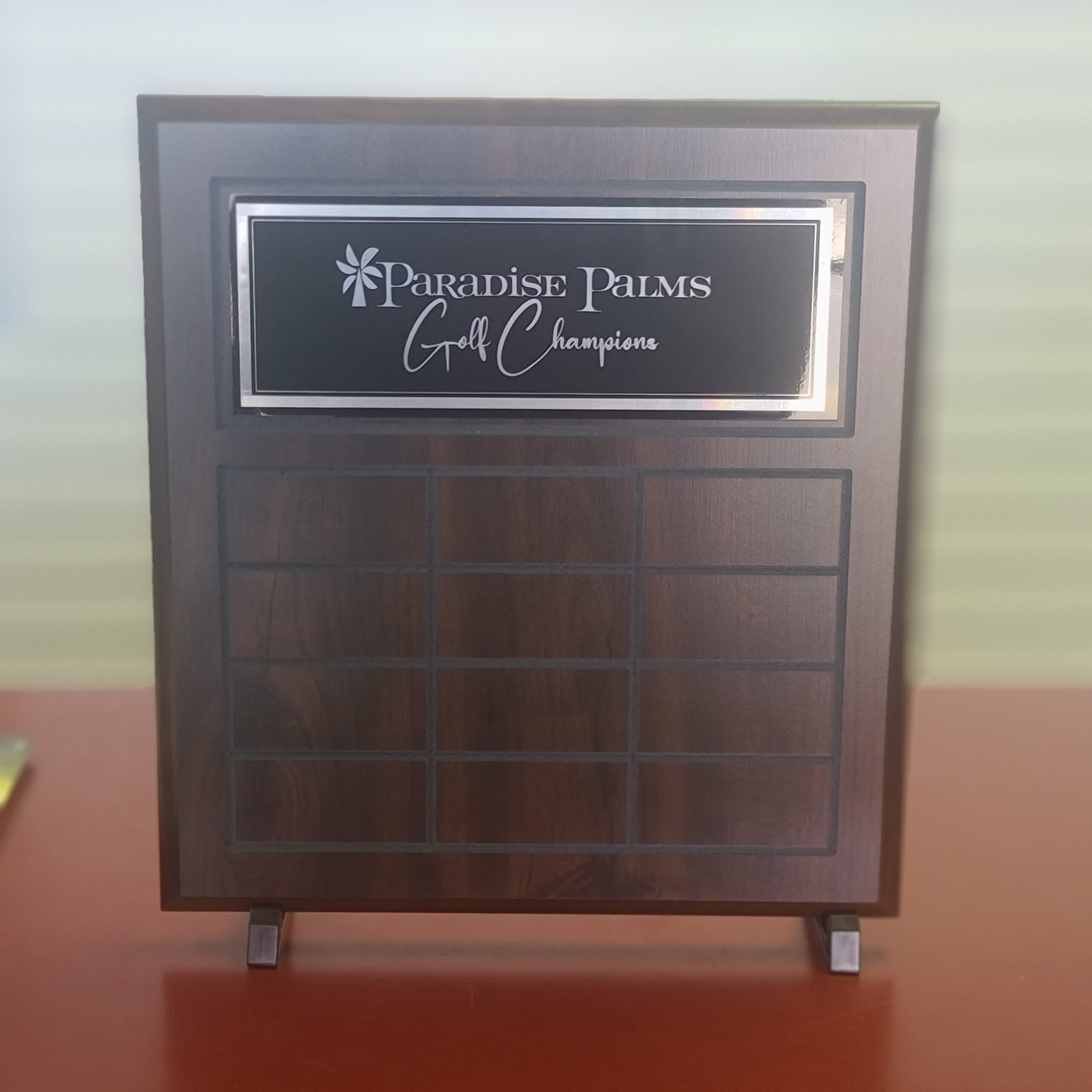 Dark walnut perpetual plaque with engraved header plate and blank rotating name plates for golf champions