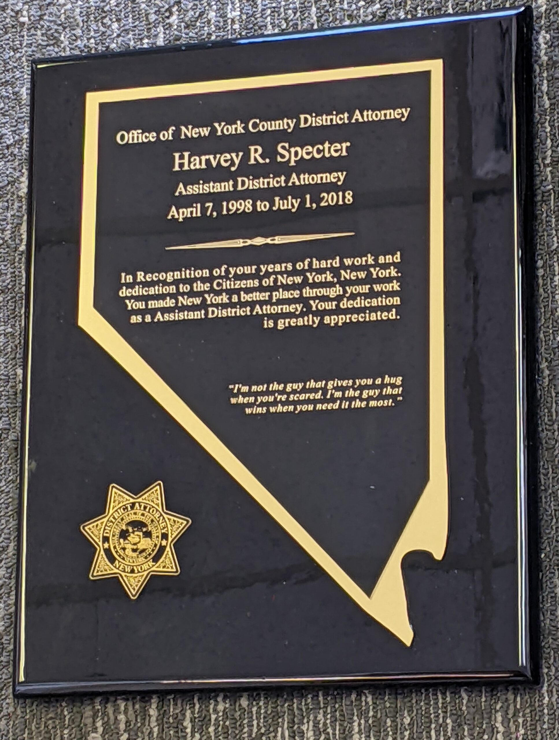 Black and gold plaque with Nevada state shape cutout and district attorney badge for years of service recognition