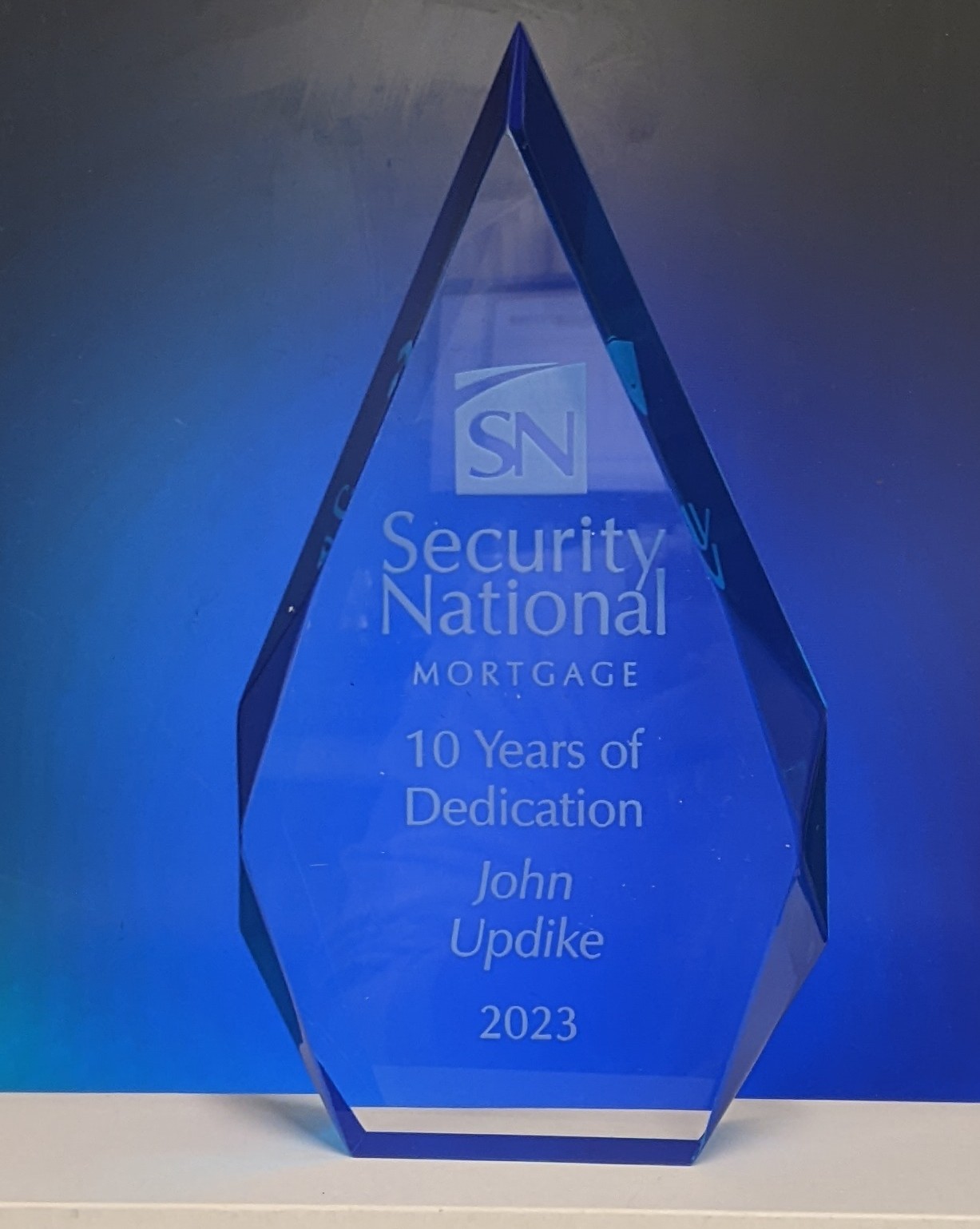 Blue crystal flame award with laser-engraved company logo and 10 years of service recognition