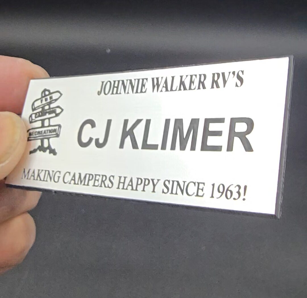 Custom engraved silver metal name tag with company logo and slogan for Johnnie Walker RV's employee, Las Vegas