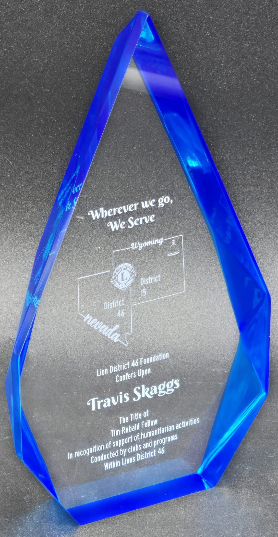 Tall blue crystal flame award with laser-engraved state map and Lions Club humanitarian recognition text